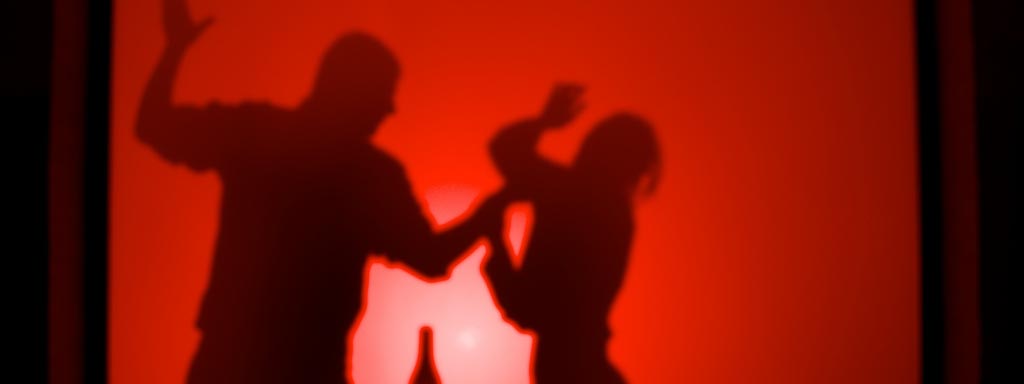 Sombra de hombre pegando a mujer