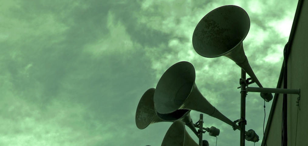Altavoces sobre cielo verdoso
